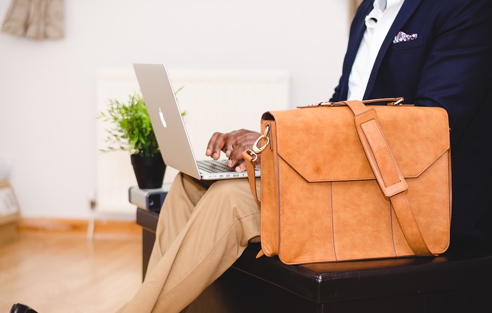 podnikatel sedí, notebook, taška